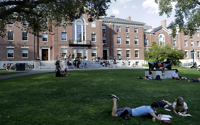 In this Wednesday, Sept. 25, 2019 photo people rest on grass while reading at Brown University, in Providence, Rhode Island (AP Photo/Steven Senne)