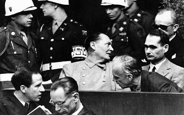 In this photo from March 27, 1946, Nazi German foreign minister Joachim von Ribbentrop, right, leans in front of Rudolf Hess, Hitler's deputy, to confer with his lawyer, lower left, while Hermann Goering, center, chief of the German air force and one of Hitler's closest aides, turns to talks with Karl Doenitz, rear right, during the Nueremberg war crime trial session. (AP Photo, File)