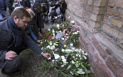 People place flowers in front of a synagogue in Halle, Germany, Oct. 10, 2019 (AP Photo/Jens Meyer)