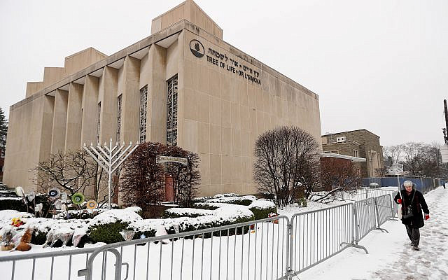 In this Monday, Feb. 11, 2019 file photo, a woman passes by the Tree of Life Synagogue in Pittsburgh's Squirrel Hill neighborhood.  (AP Photo/Keith Srakocic)