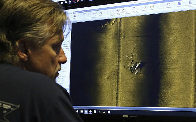 Rob Kraft, director of undersea operations at Vulcan Inc., reviews sonar scans of a warship from the World War II Battle of Midway that was found by the crew of the research vessel Petrel, Sunday, Oct. 20, 2019, off Midway Atoll in the Northwestern Hawaiian Islands. (AP Photo/Caleb Jones)