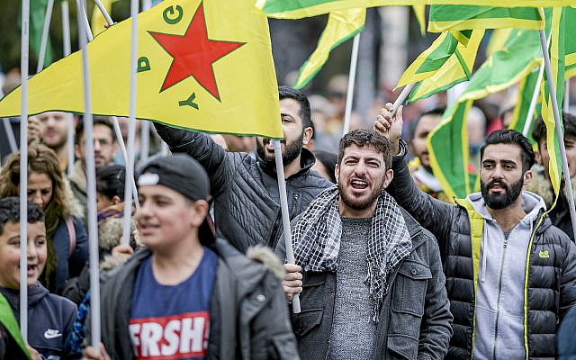 People with flags of the Kurdish YPG protest against the Turkish invasion in Kurdish territories in northern Syria in Hamburg, Germany on October 12, 2019. (Axel Heimken/dpa via AP)