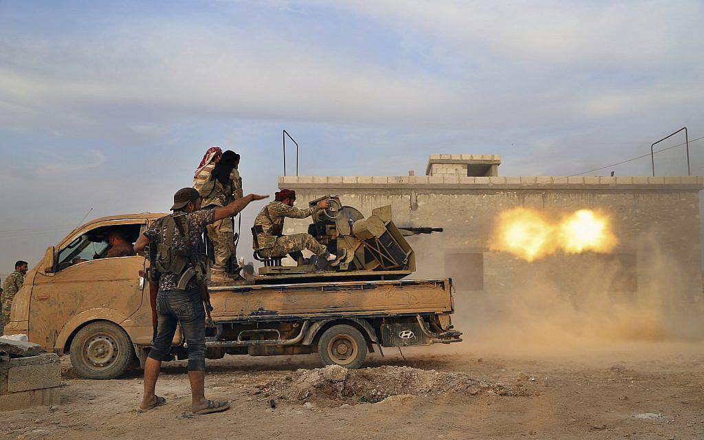 In this photo from October 14, 2019, Turkey-backed Syrian opposition fighters fire a heavy machine-gun towards Kurdish fighters, in Syria's northern region of Manbij. (AP Photo)