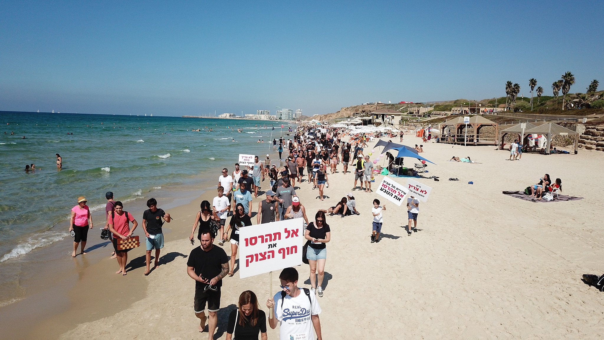Surfers protest plans for breakwater off last open beach in Tel