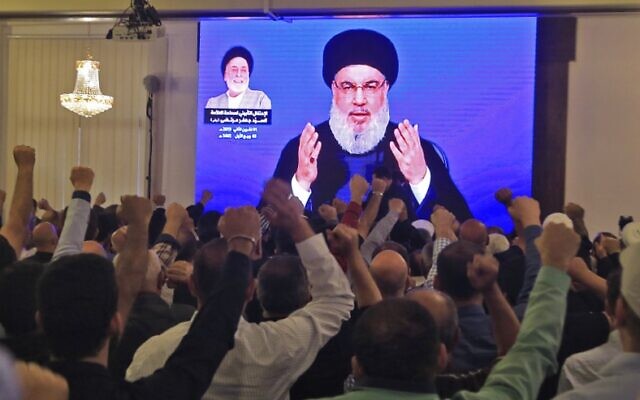 Supporters of Hassan Nasrallah, the head of Lebanon's Hezbollah terror group, watch him speak through a giant screen at a mosque in the Lebanese capital Beirut's southern suburbs on November 1, 2019. (AFP)