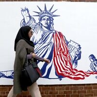 An Iranian woman walks past a new mural painted on the walls of the former US embassy in the capital Tehran, on November 2, 2019. (Atta Kenare/AFP)