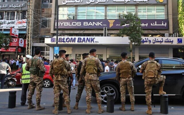 Members of the Lebanese army surround protesters gathering outside a bank during continuing anti-corruption demonstrations on November 4, 2019 in south Lebanon's capital Sidon. (Mahmoud ZAYYAT / AFP)