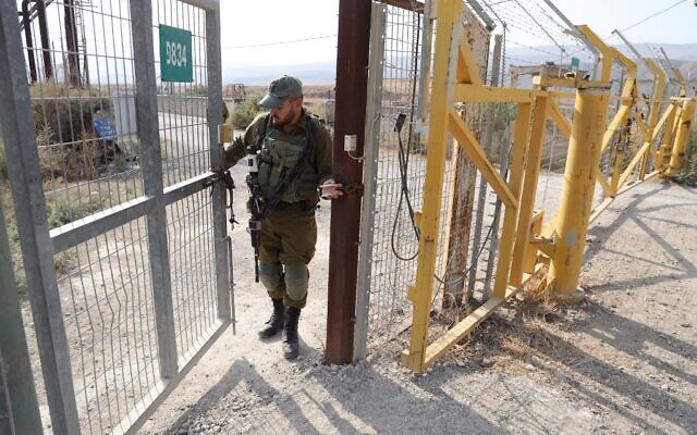 A picture taken on November 8, 2019, shows an Israeli soldier closing a border gate on the Israeli side of the border at the Jordan Valley site of Naharayim. (Menahem Kahana/AFP)