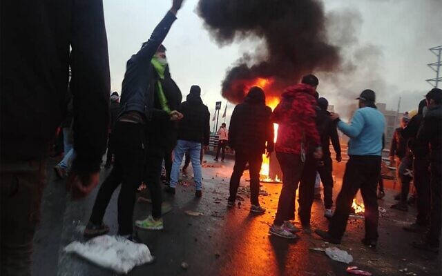 Des manifestants iraniens se rassemblent autour d'un feu lors d'une manifestation contre l'augmentation du prix de l'essence dans la capitale, Téhéran, le 16 novembre 2019. (AFP)