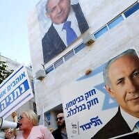 Supporters of then-prime minister Benjamin Netanyahu chant slogans and hold up signs in support of him, during a counterrally outside the Likud party headquarters in Tel Aviv, on November 22, 2019, as Labor Party supporters demonstrate against him nearby. (Jack Guez/AFP)