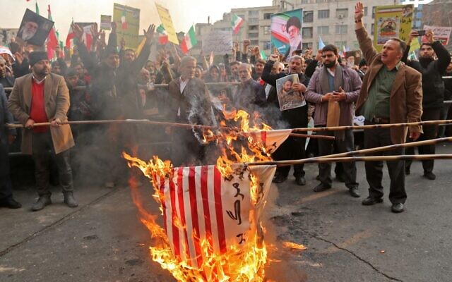 Iranian pro-government demonstrators burn makeshift US flags as they gather in the capital Tehran's central Enghelab Square on November 25, 2019, to condemn days of "rioting" that Iran blames on its foreign foes. (ATTA KENARE / AFP)