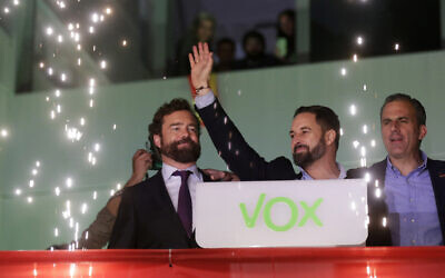 Santiago Abascal, leader of far-right Vox Party, waves to supporters as fireworks go off outside the party headquarters after the announcement of the general election first results, in Madrid, Sunday, Nov. 10, 2019. (AP Photo/Andrea Comas)