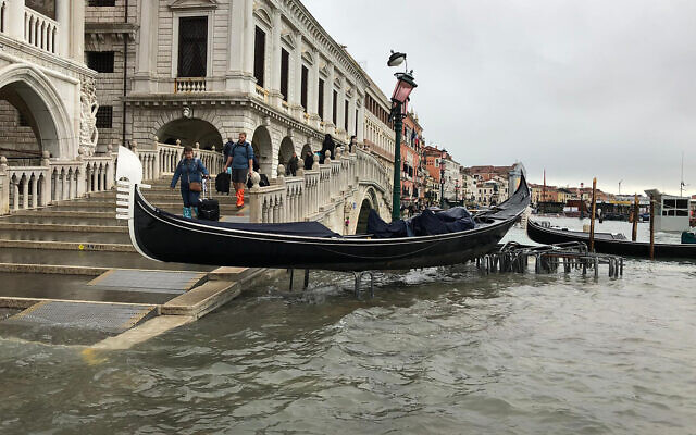 A gondola boat is stranded atop a bike rack after high tide in Venice, Italy, November 13, 2019.  (Alessandra Rallo/AP)