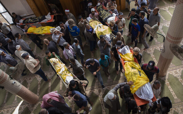 Palestinian mourners carry out the bodies of Rasmi Abu Malhous and seven members of his family who were killed in overnight Israeli missile strikes that targeted their house, during their funeral at a mosque in Deir al-Balah, central Gaza Strip,, November 14, 2019. (AP Photo/Khalil Hamra)