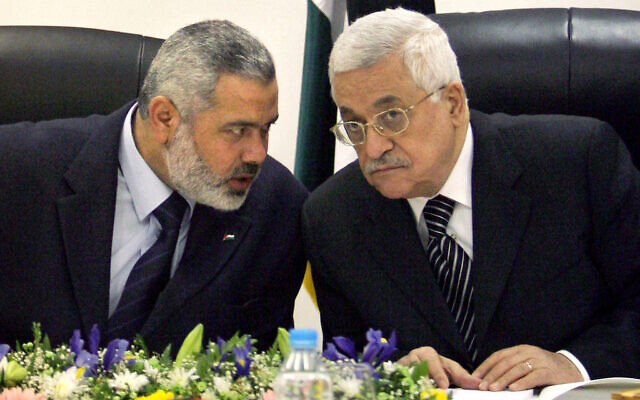 Palestinian Authority President Mahmoud Abbas, right, and then Palestinian Prime Minister Ismail Haniyeh of Hamas, left, speak as they head the first cabinet meeting of the new coalition government at Abbas' office in Gaza City, March 18, 2007. (AP Photo/Khalil Hamra)
