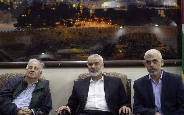 Yahya Sinwar (right), the Hamas terror group's leader in the Gaza Strip, sits with Hamas chief Ismail Haniyeh (center), as they meet the Head of the Central Elections Commission, Hanna Nasser, in Gaza City, on October 28, 2019. (AP Photo/Khalil Hamra)