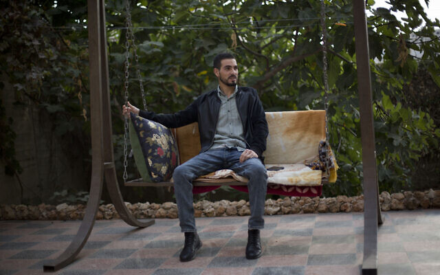 Palestinian Karam Qawasmi, who was shot in the back by Israeli forces in an incident caught on video last year, sits in his garden, in the West Bank city of Hebron, Sunday, Nov. 10, 2019. (AP Photo/Majdi Mohammed)