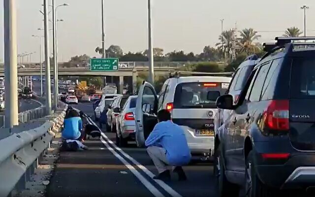 Illustrative: Screen capture from video of Israeli motorists crouching beside their vehicles on a major highway as sirens blare warning of incoming rocket fire from the Gaza Strip, November 12, 2019. (Twitter)