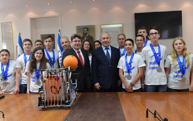Illustrative: Prime Minister Benjamin Netanyahu (center right) and Science Minister Ofir Akunis greet the Israeli teen delegation upon their return from the unofficial 'Robotics Olympics' in Dubai. (Kobi Gideon/GPO)