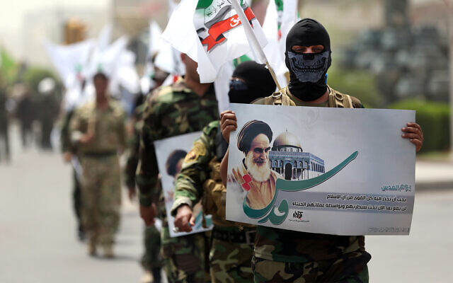Iran-linked fighters with a portrait of Iran's late leader Ayatollah Khomeini in Baghdad, Iraq, during a parade marking Quds Day, July 25, 2014. (AP Photo/Hadi Mizban)