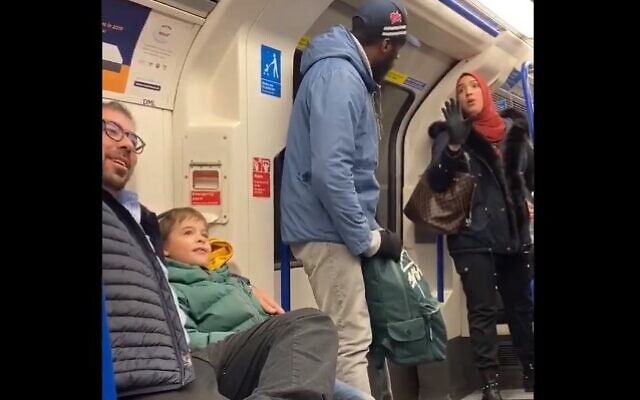A Muslim woman (R) is seen trying to stop a man (C) from shouting anti-Semitic abuse at Jewish family with small children on the London Underground on November 22, 2109 (Screencapture/Twitter)