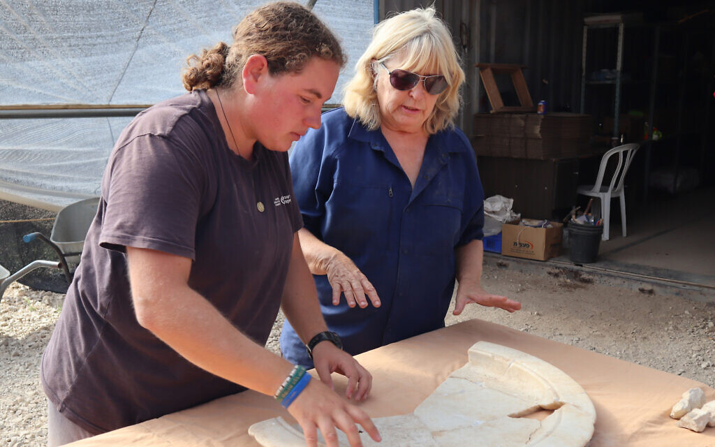IAA archaeologist Dr. Tali Erickson-Gini (right) examines a marble tray from the altar area of the Byzantine church near Ashkelon. (Anat Rasiuk, Israel Antiquities Authority)