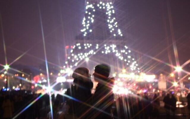 A couple kiss in front of the Eiffel tower during the New Year's celebrations in Paris, on January 1, 2020. (Photo by MARTIN BUREAU / AFP)