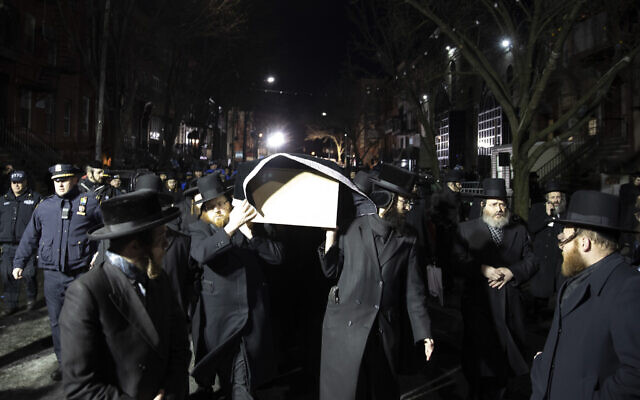 Orthodox Jewish men carry the casket with shooting victim Mindel Ferencz outside a Brooklyn synagogue, Wednesday, December 11, 2019, in New York. Ferencz was killed in a shooting attack on a kosher supermarket. (AP Photo/Mark Lennihan)