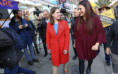 Britain’s Liberal Democrat leader Jo Swinson, left, walks with the party’s candidate for Finchley and Golders Green Luciana Berger as she arrives for a visit to a mental health enterprise in North London, Nov. 6, 2019. (Aaron Chown/PA via AP)
