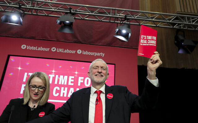Jeremy Corbyn, Leader of Britain's opposition Labour Party, holds a copy of the manifesto next to Rebecca Long-Bailey on stage at the launch of Labour's General Election manifesto, at Birmingham City University, England, Thursday, Nov. 21, 2019.  (AP Photo/Kirsty Wigglesworth)