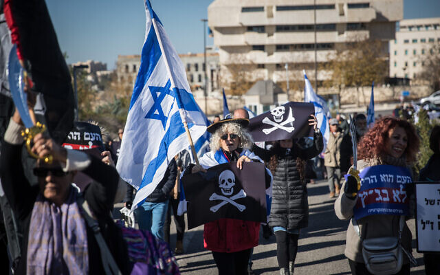 Supporters of Israeli Prime Minister Benjamin Netanyahu and activists protest against the Israeli legal system outside a court hearing at the Supreme Court in Jerusalem on whether a lawmaker facing criminal indictment can be tapped to form a coalition, December 31, 2019. (Yonatan Sindel/Flash90)