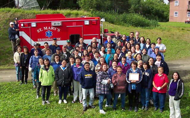 In 2003, while stationed in Alaska, Hall and her team bought an ambulance with grant money. The ambulance would serve the Village of St. Mary’s. Hall is standing in the back row, hand on the ambulance. (Courtesy/ Cpt. Dana Hall)
