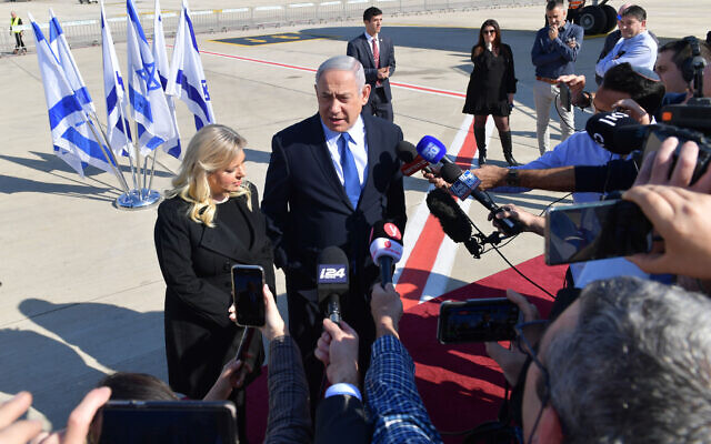 Prime Minister Benjamin Netanyahu and his wife Sara Netanyahu speaking to the press from the tarmac of Ben-Gurion Airport on December 4, 2019. (Kobi Gideon / GPO)