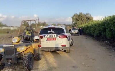 A police car and other vehicles are seen at the site where a body with gunshot wounds was found in the central city of Ramat Hasharon, December 27, 2019. (Screen capture: Twitter)