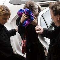 A British teenager, center, accused of falsely claiming she was raped by Israeli tourists, covers her face as she arrives for her trial at the Famagusta District Court in Paralimni in eastern Cyprus, on December 30, 2019. (Iakovos Hatzistavrou/AFP)