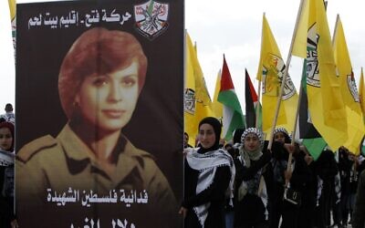 Supporters of the Palestinian Fatah movement march with a poster of female terrorist Dalal al-Mughrabi, who took part in the 1978 Coastal Road massacre in Israel, during a rally marking the 55th foundation anniversary of the political party in the West Bank town of Bethlehem on January 1, 2020. (Musa AL SHAER / AFP)