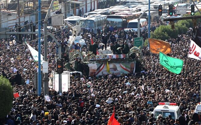 A large crowd surrounds the coffins of slain top commander Qasem Soleimani and Iraqi paramilitary chief Abu Mahdi al-Muhandis, as they are transported atop a vehicle after their arrival at Ahvaz International Airport in southwestern Iran on January 5, 2020. (FATEMEH RAHIMAVIAN / fars news / AFP)