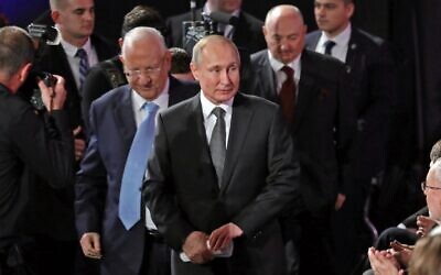 Israeli President Reuven Rivlin escorts his Russian counterpart Vladimir Putin to his seat during the Fifth World Holocaust Forum at the Yad Vashem Holocaust memorial museum in Jerusalem on January 23, 2020. Behind them is the Forum’s Moshe Kantor (Abir SULTAN / POOL / AFP)