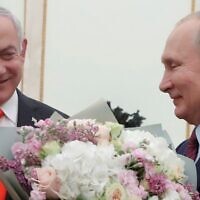 Russian President Vladimir Putin (right) with a bouquet of flowers and Prime Minister Benjamin Netanyahu at the Kremlin in Moscow on January 30, 2020. (Maxim Shemetov/Pool/AFP)