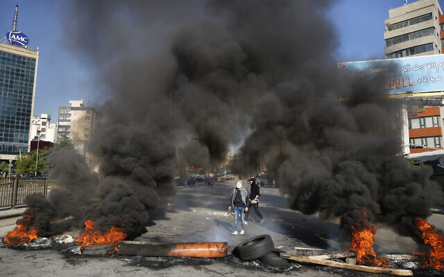 Anti-government protesters burn tires during ongoing protests after weeks of calm in Beirut, Lebanon, January 14, 2020. (Hussein Malla/AP)