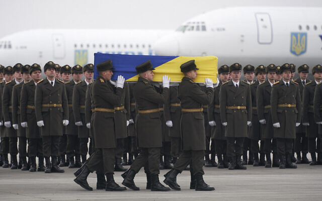 Honor guards carry a coffin of one of the eleven Ukrainian victims of the Ukrainian 737-800 plane that was shot down in error by Iran on the outskirts of Tehran, during a memorial ceremony at Borispil international airport outside Kyiv, Ukraine, January 19, 2020. (Ukrainian Presidential Press Office via AP)