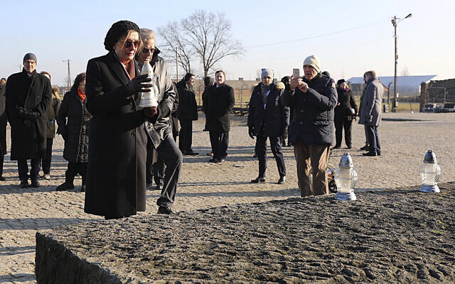 In this image provided by the US Consulate General in Krakow, US House Speaker Nancy Pelosi places a memorial light on the monument to some 1.1 million victims of the World War II Nazi death camp of Auschwitz-Birkenau during a visit to the site of the former camp just days before the 75th anniversary of its 1945 liberation by the Soviet troops, at the Auschwitz-Birkenau Museum, in southern Poland, on Tuesday, Jan. 21, 2020. (US Consulate General in Krakow via AP)