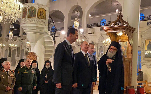 Russian President Vladimir Putin, third right, and Syrian President Bashar Assad, center, visiting an Orthodox cathedral for Christmas, in Damascus, Syria, January 7, 2020. (Syrian Presidency via AP)