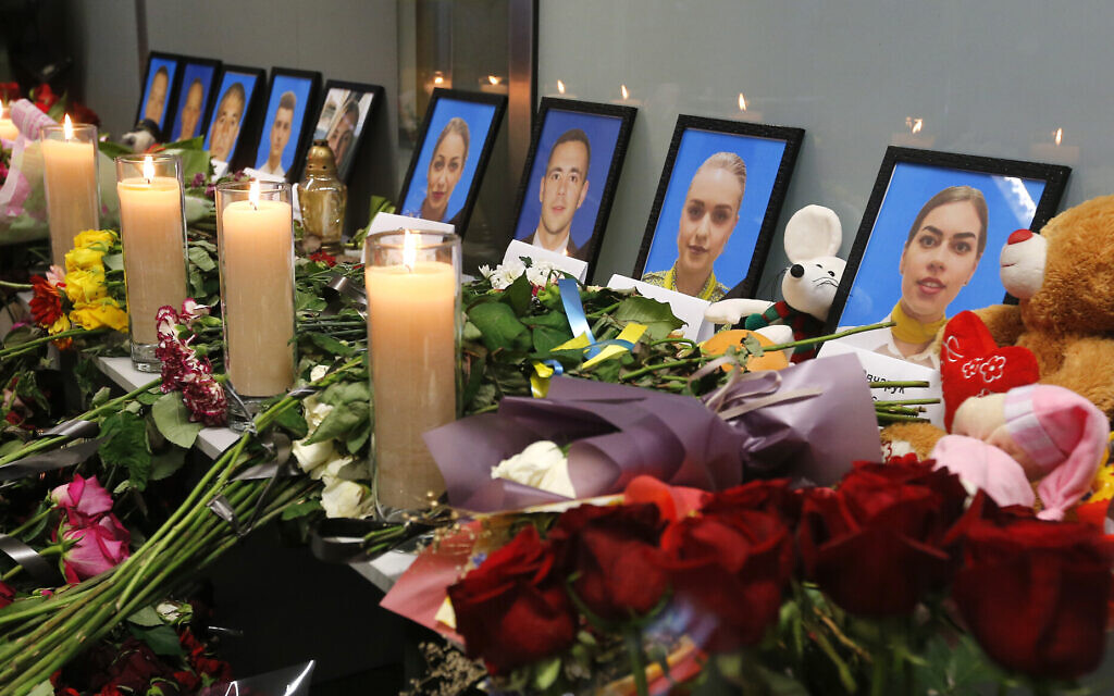 Flowers and candles are placed in front of portraits of the flight crew members of the Ukrainian 737-800 plane that crashed on the outskirts of Tehran, at a memorial inside Borispil international airport outside Kyiv, Ukraine, Saturday, Jan. 11, 2020. (AP Photo/Efrem Lukatsky)