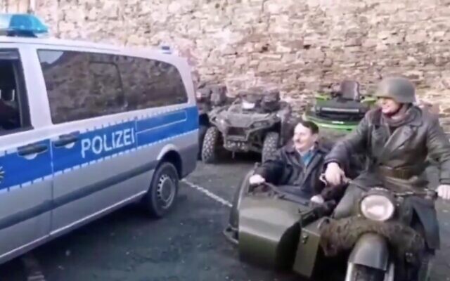 Screen capture from video of a man dressed as Hitler riding in a motorcycle sidecar at an event in in Augustusburg, near Chemnitz, Germany, January 2020. (Twitter)