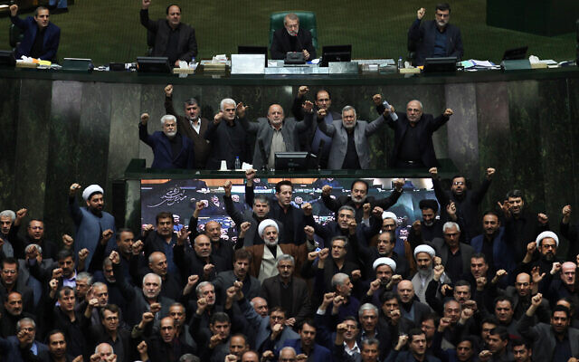 Iranian lawmakers chant anti-American and anti-Israeli slogans to protest against the US killing of Iranian general Qassem Soleimani, at the start of an open session of parliament in Tehran, Iran, Jan. 5, 2020. (Mohammad Hassanzadeh/Tasnim News Agency via AP)
