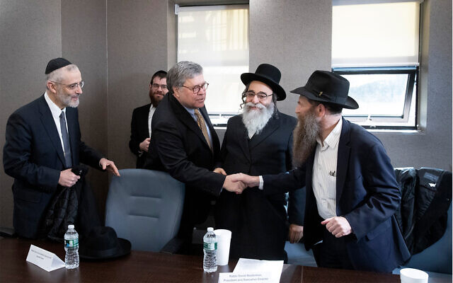 Rabbi David Niederman stands between US Attorney General William Barr and Rabbi Eli Cohen, who shake hands at a meeting with Jewish leaders at the Boro Park Jewish Community Council, January 28, 2020 in New York. (AP/Mark Lennihan)