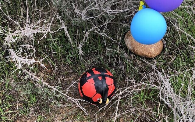 An explosives-laden soccer ball that was apparently flown from the Gaza Strip using balloons is seen in an open area of the Sha'ar Hanegev Regional Council on January 23, 2019. (Courtesy)