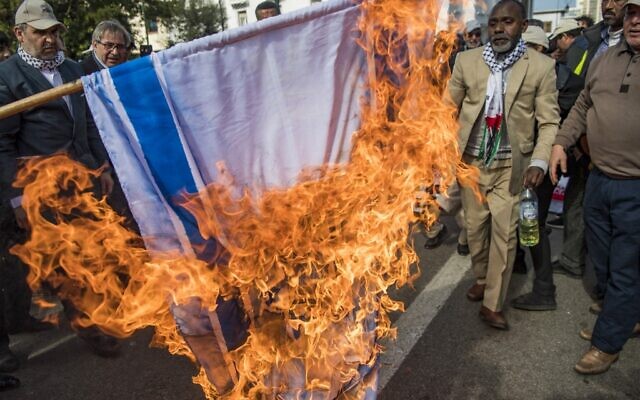 Illustrative: Moroccans burn the Israeli flag during a demonstration against the US Middle East peace plan in the capital Rabat on February 9, 2020. (Fadel Senna/AFP)