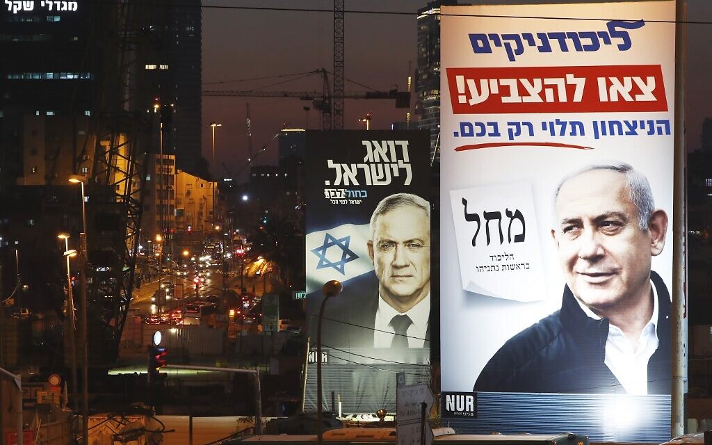 A Blue and White electoral billboard shows retired general Benny Gantz, background, and a Likud electoral billboard shows Prime Minister Benjamin Netanyahu, on February 26, 2020 in the Israeli city of Bnei Brak. (JACK GUEZ / AFP)
